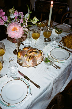 a table set with plates, silverware and flowers