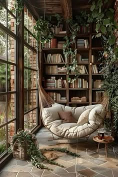 a hammock hanging from the ceiling in a room filled with books and plants