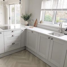 Add a cooktop stove to your seamless countertops for a noticeable modern look and functional purpose. Maintaining the look of a perfectly white kitchen can be limiting, so use complementary brushed nickel hardware to introduce a sense of embellishment. Shaker-style cabinets are a timeless addition that will never disappoint you regarding decorative opportunities. Light wood herringbone floors complete the look for a modern, airy design...   Image: wrightathomescotland