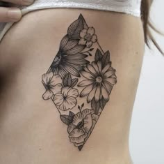 a woman's stomach with black and white flowers on the side, in front of her belly