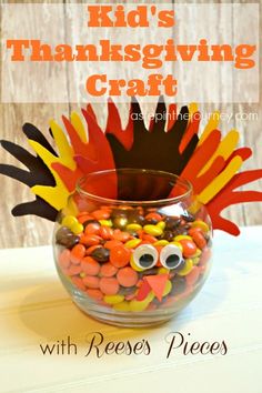 a glass bowl filled with candy corn and fake turkeys for kids'thanksgiving craft