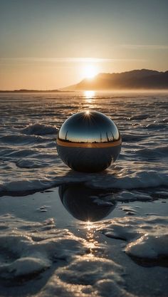 the sun is setting behind an object in the middle of some water with ice floes