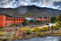 an orange building with mountains in the background