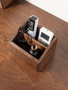 a wooden box with electronics in it on top of a wood table next to a mirror