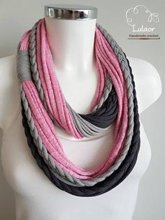 a white mannequin wearing a gray and pink scarf on it's neck