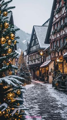 a street with lots of christmas decorations and lights on the buildings in front of it