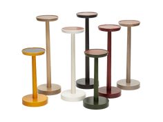 four different colored pedestals with mirrors on each side and one standing in the middle