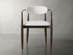 a white chair sitting on top of a floor next to a gray wall and wooden legs