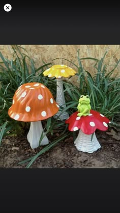 three small plastic mushrooms sitting in the grass