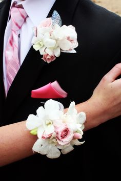 a man in a suit and pink tie with flowers on his lapel flower bouquet