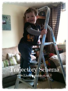 a little boy standing on top of a ladder