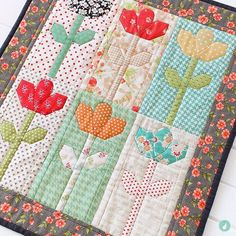 a close up of a quilt on a table topper with flowers in the center