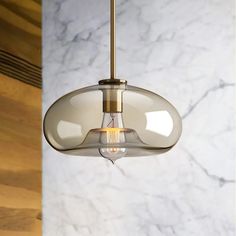 a light fixture hanging from a ceiling in a room with marble walls and flooring