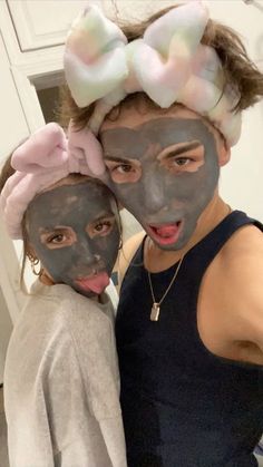 two girls with their faces painted like bow ties and wearing black face masks, posing for the camera