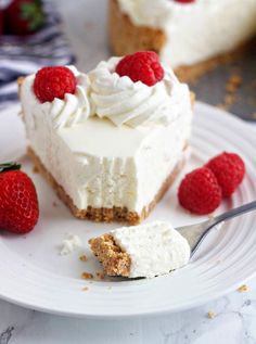 a piece of cheesecake on a plate with raspberries next to it and a fork