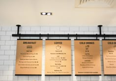 three menus hanging on the wall in a restaurant