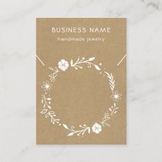 a business card with a floral wreath on it