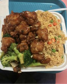 a plastic container filled with rice and meat next to broccoli on top of it