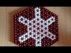 a beaded ornament made to look like a star on a wooden table