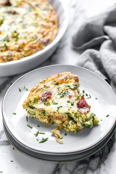 a slice of quiche on a plate next to a casserole dish