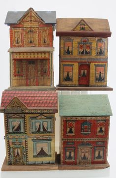 three small wooden buildings with different colors and designs on the front, one in red, one in blue