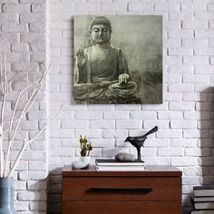 a buddha statue sitting on top of a wooden dresser next to a white brick wall