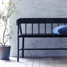 a black bench sitting next to a potted plant