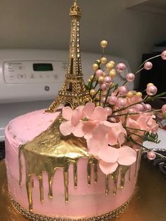 a pink and gold cake with the eiffel tower in the background