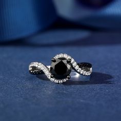 This captivating ring features a mesmerizing swirl design, combining the contrasting beauty of black and white stones. Two ribbons, one lined with black stones, the other with shimmering white stones, twist and swirl together to create the ring's shank. Its unique and contemporary style is sure to turn heads and add a touch of drama to any outfit.Carat Weight: 2.3 ctStone Size: 7 mmStone Type: Jeulia® StoneNumber of Stones: 1 Stone Color: Fancy BlackStone Shape: RoundCarat Weight: 0.798 ctStone Unique Black Wedding Rings, Unique Black Rings, Love Black And White, Black Wedding Rings, Black Stones, White Stones, Rings Bands, Swirl Design, Love Black