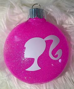 a pink ornament with a silhouette of a woman's head on it