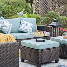 an outdoor patio with wicker furniture and blue cushions