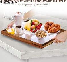 a breakfast tray with croissants, fruit and coffee