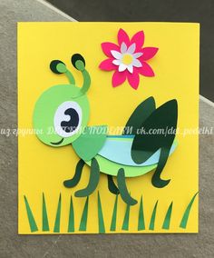 a paper card with a green bug and flower on it