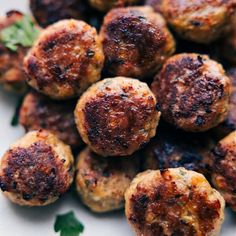 some meatballs are sitting on a plate with parsley sprinkled around them