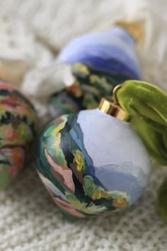 three colorful ornaments sitting on top of a white blanket