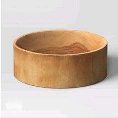 a wooden bowl sitting on top of a white table