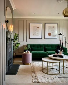 a living room with green couches and art on the wall