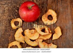 an apple is cut into pieces and sitting on a wooden table with the peels removed