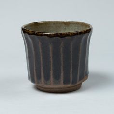 a brown and black cup sitting on top of a table