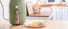 a bowl of pasta on a table next to an electric cooker