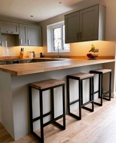 a kitchen with wooden counter tops and stools