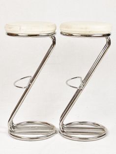 two chrome stools sitting side by side on a white background