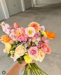 a person holding a bouquet of flowers in their hand