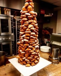 a tower of powdered donuts sitting on top of a white plate in a kitchen