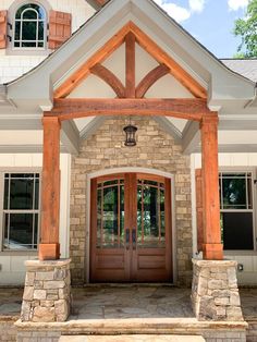 the front entrance to a home with stone and wood