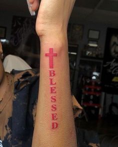 a person with a cross tattoo on their arm