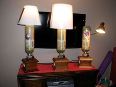 two lamps sitting on top of a wooden table next to a tv monitor and lamp shade