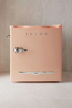 an old fashioned pink refrigerator sitting on top of a white floor next to a wall