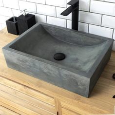 a bathroom sink sitting on top of a wooden counter next to a black faucet