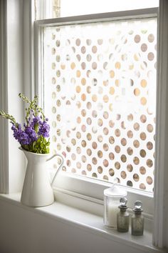 a vase with flowers sitting on a window sill